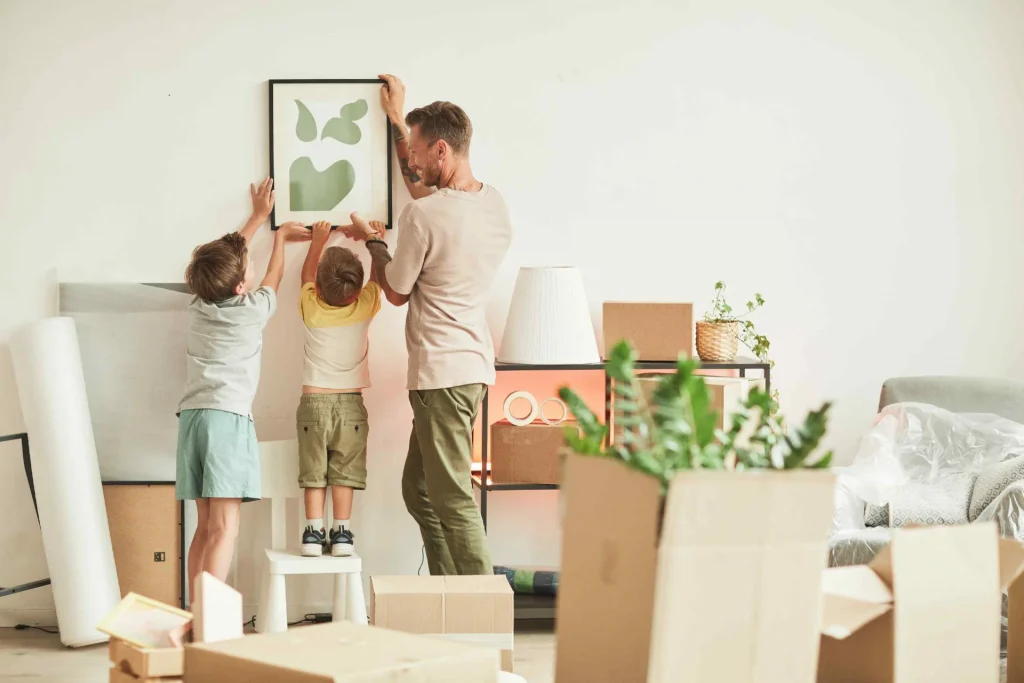 Father and Two Sons Hanging Pictures in Columbia, MO